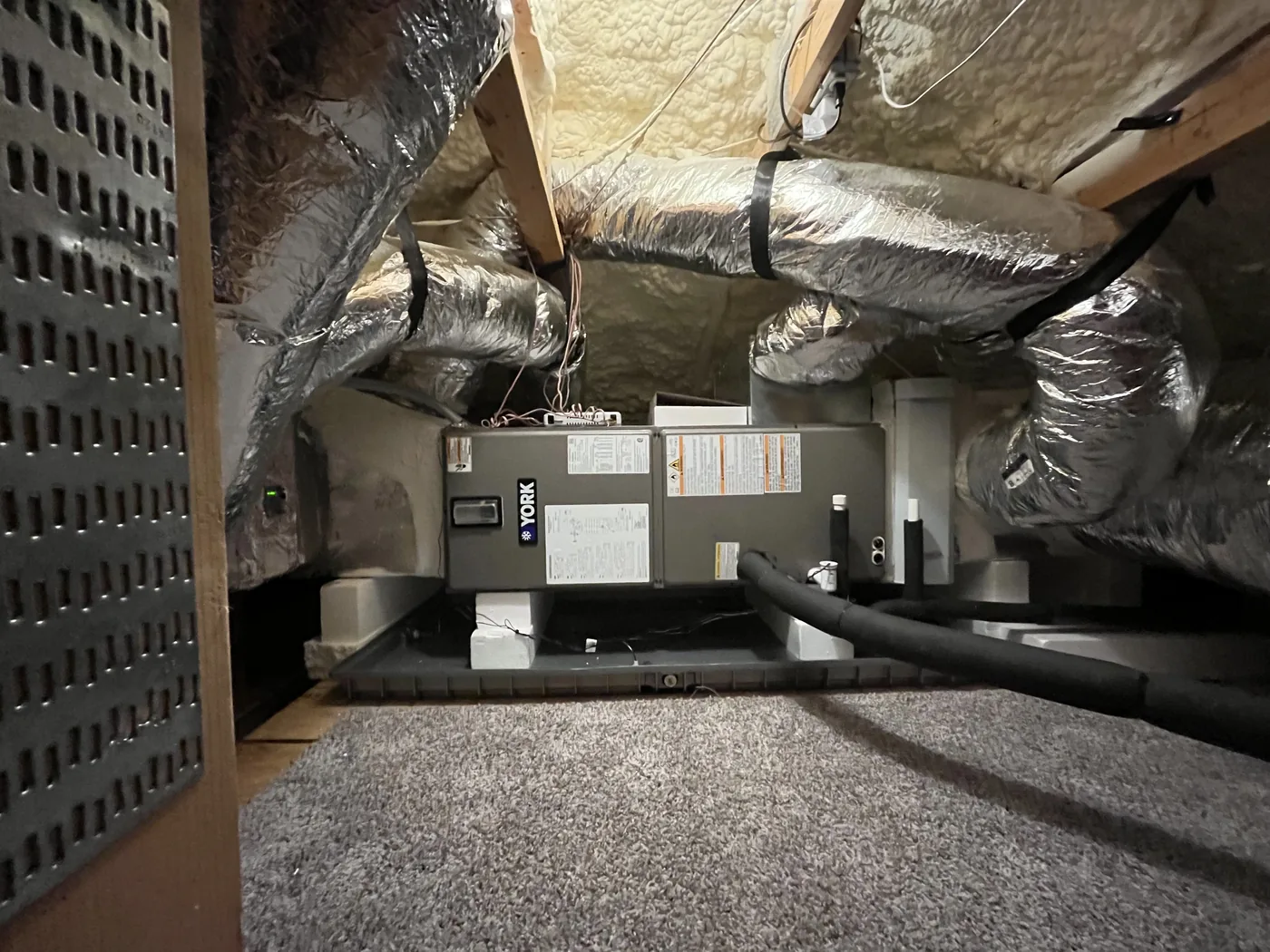 A clean MLD Services York air-handler installation in a Central Texas attic, with insulated ductwork neatly routed.